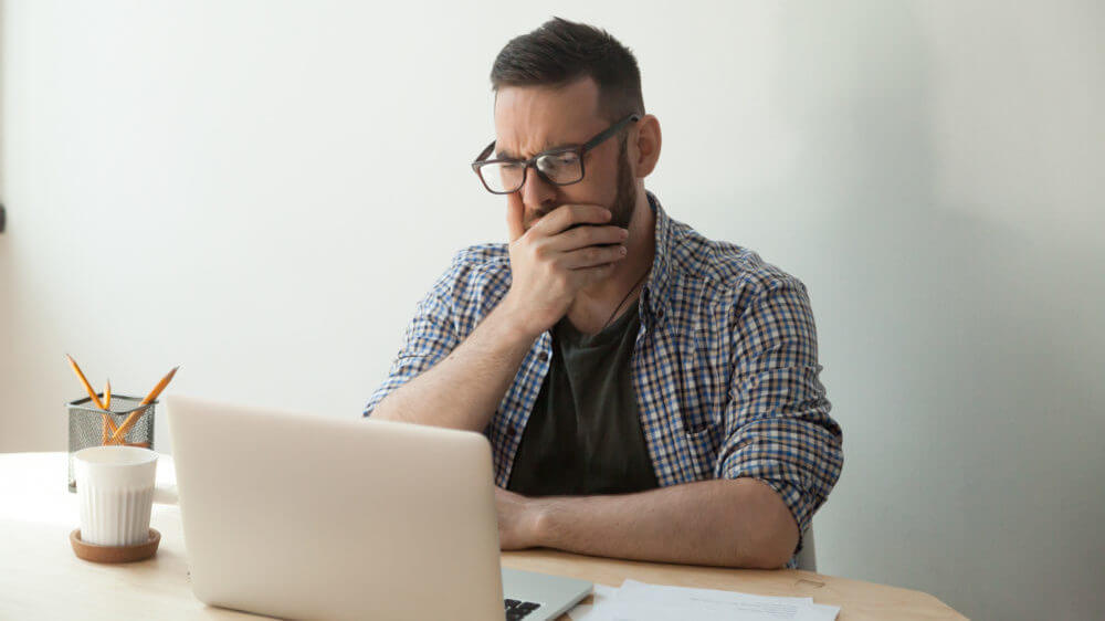 Man reading computer upset