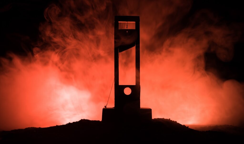 Horror view of Guillotine. Close-up of a guillotine on a dark foggy background.